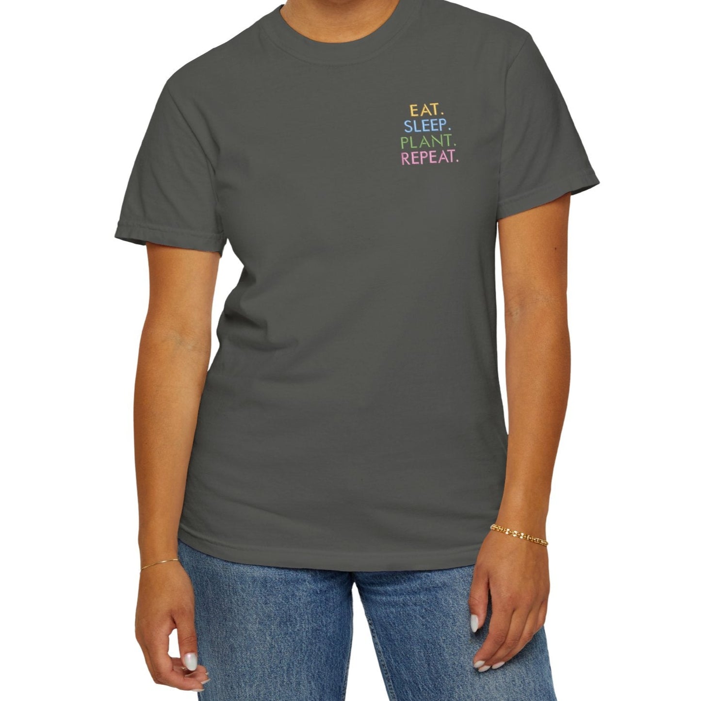 Person wearing a gray t-shirt with colorful embroidered text on a white background
